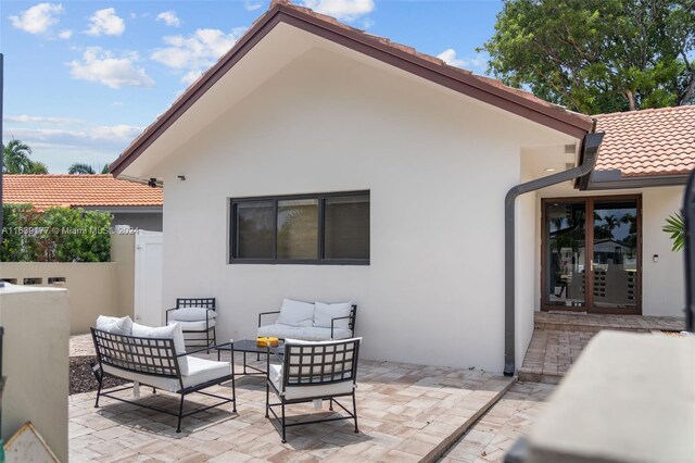 back of property with an outdoor living space and a patio area