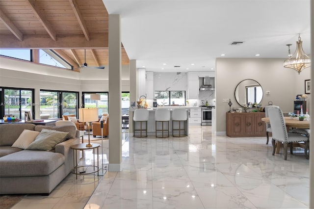 living room with beam ceiling, wood ceiling, high vaulted ceiling, and an inviting chandelier