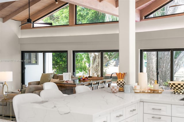 living room featuring wood ceiling, ceiling fan, beam ceiling, and high vaulted ceiling