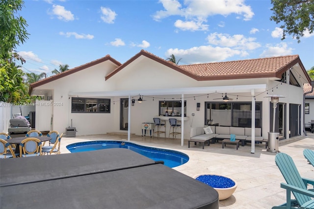 rear view of house with an outdoor living space, a fenced in pool, ceiling fan, and a patio area