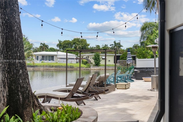 view of patio with a water view and a hot tub