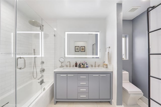 full bathroom featuring enclosed tub / shower combo, toilet, vanity, and tile patterned floors