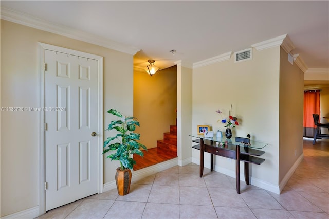 foyer entrance with crown molding, visible vents, stairway, light tile patterned flooring, and baseboards