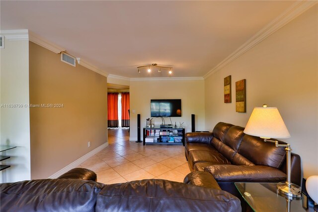 living area featuring light tile patterned floors, baseboards, visible vents, and ornamental molding