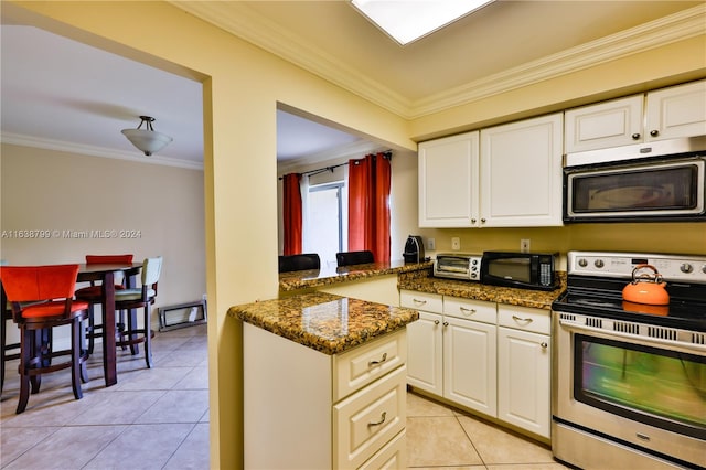 kitchen with appliances with stainless steel finishes, ornamental molding, light tile patterned floors, and dark stone countertops