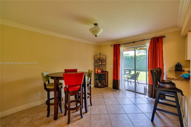 dining room featuring light tile patterned floors and crown molding