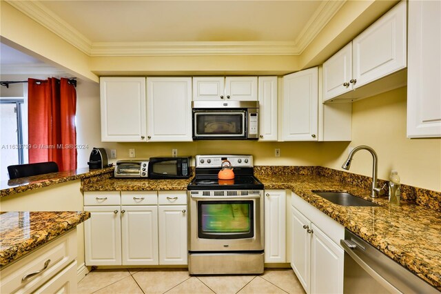 kitchen with light tile patterned flooring, stainless steel appliances, a sink, white cabinets, and crown molding