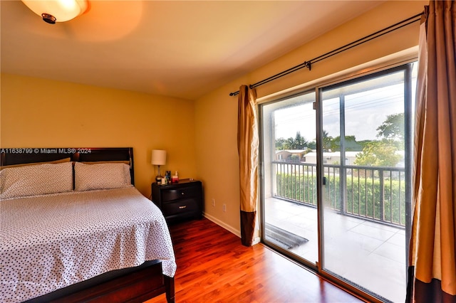 bedroom with dark hardwood / wood-style flooring and access to exterior