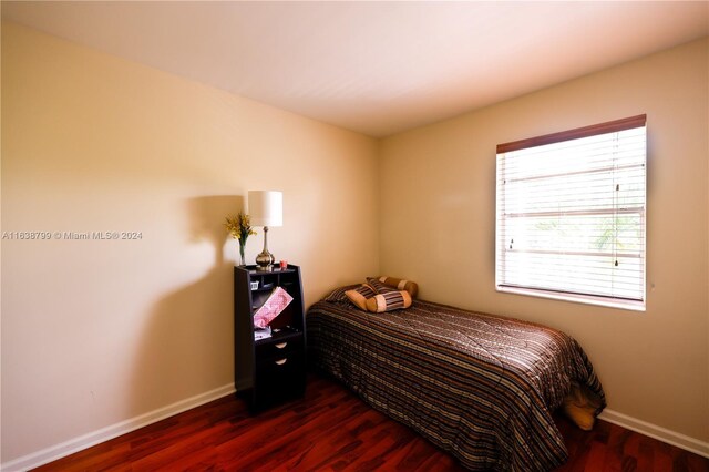 bedroom featuring dark wood-type flooring and baseboards