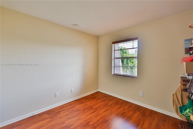 unfurnished room featuring baseboards and wood finished floors