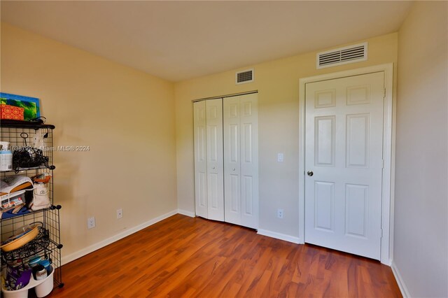 bedroom with hardwood / wood-style floors and a closet