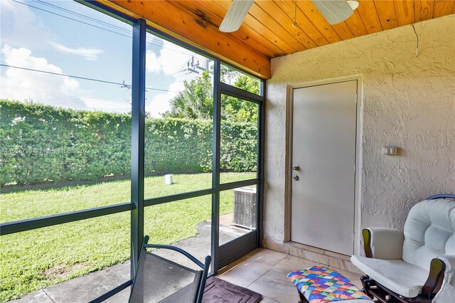 sunroom with a ceiling fan and wood ceiling