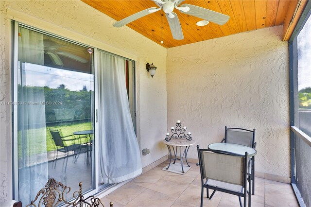 sunroom featuring ceiling fan and wood ceiling