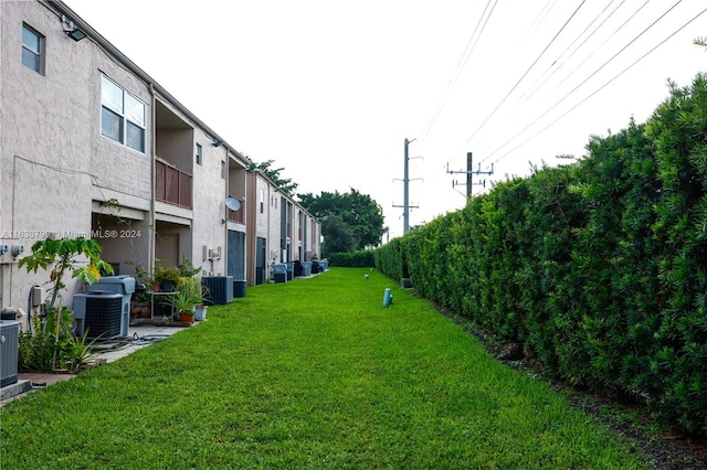 view of yard with a balcony and central air condition unit