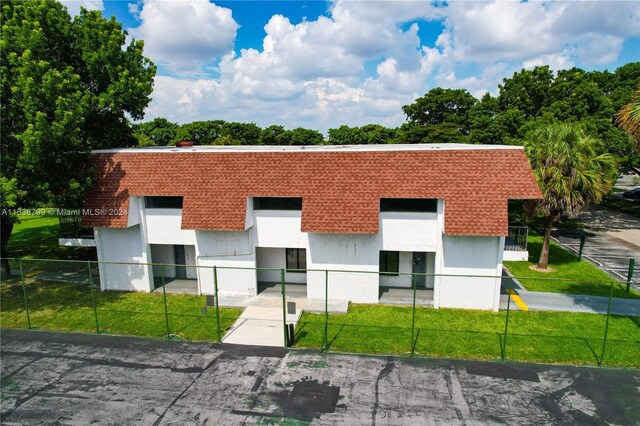 view of front of home with a fenced front yard, a front yard, and stucco siding