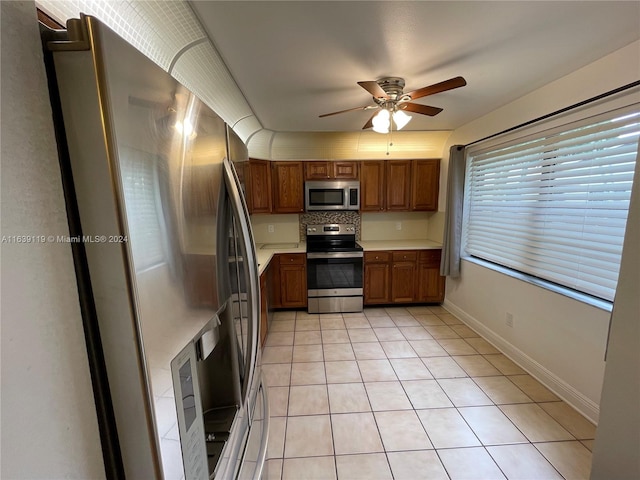 kitchen with appliances with stainless steel finishes, tasteful backsplash, light tile patterned floors, and ceiling fan