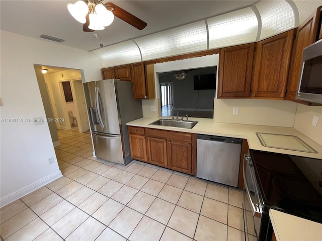 kitchen featuring appliances with stainless steel finishes, light tile patterned floors, sink, and ceiling fan