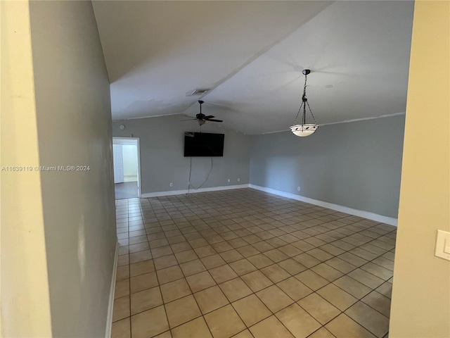 tiled empty room with ceiling fan and vaulted ceiling