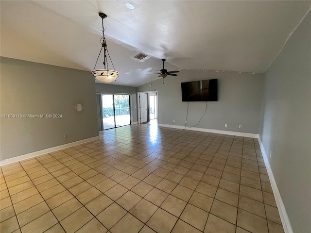 spare room with ceiling fan, light tile patterned floors, and vaulted ceiling