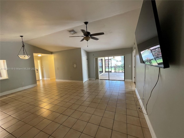 spare room featuring ceiling fan, lofted ceiling with skylight, and tile patterned flooring