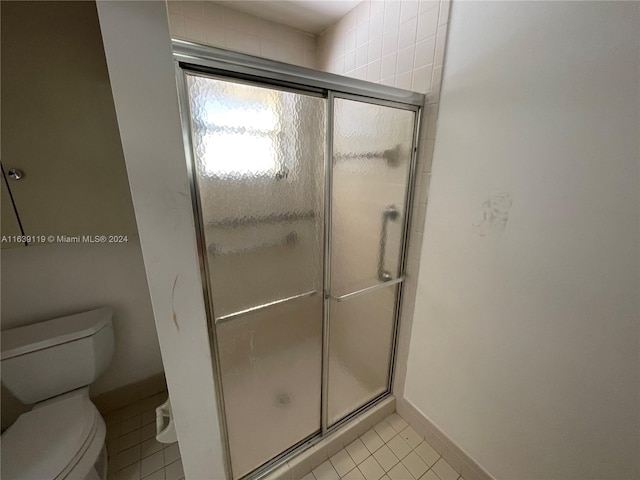 bathroom with toilet, tile patterned floors, and an enclosed shower