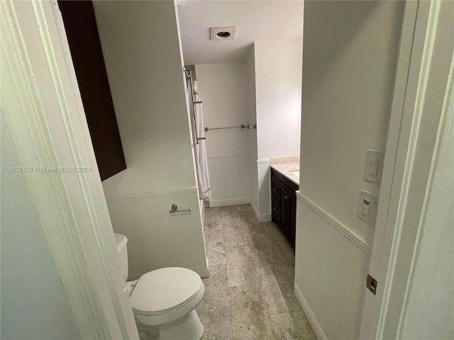 bathroom featuring vanity, tile patterned flooring, and toilet