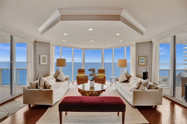 living room featuring a water view, floor to ceiling windows, and hardwood / wood-style flooring