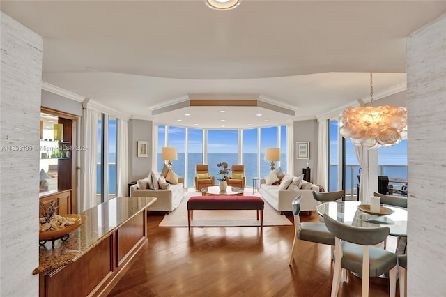 interior space with a notable chandelier, dark wood-type flooring, ornamental molding, expansive windows, and a water view