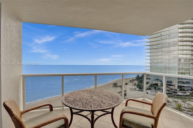 balcony featuring a beach view and a water view