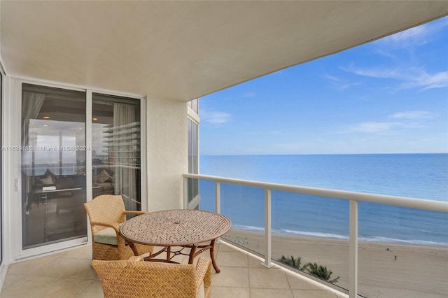 balcony featuring a view of the beach and a water view