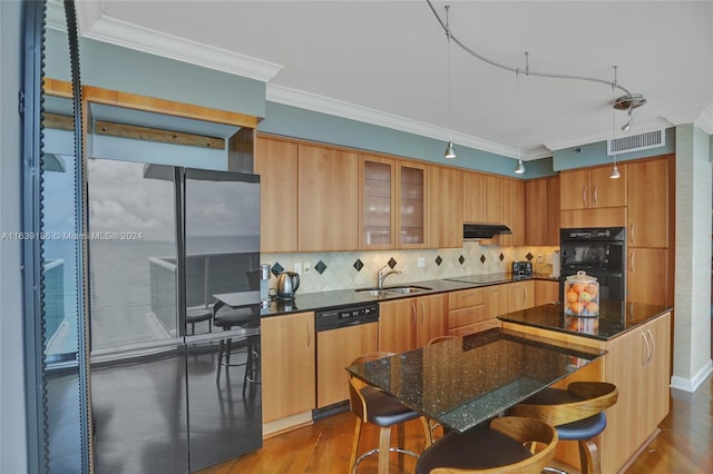 kitchen with crown molding, black appliances, wood-type flooring, and tasteful backsplash