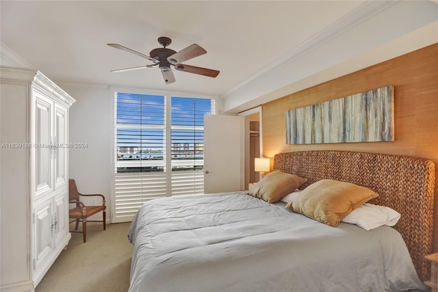 carpeted bedroom featuring ceiling fan and ornamental molding