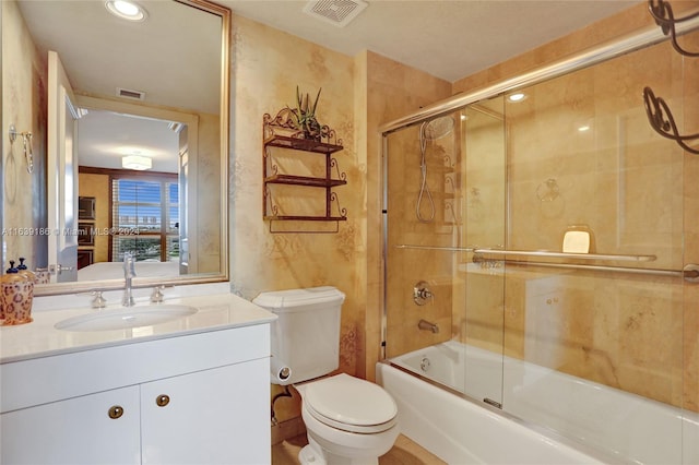 full bathroom featuring toilet, bath / shower combo with glass door, and vanity