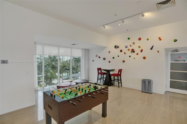 recreation room featuring track lighting and light tile patterned floors