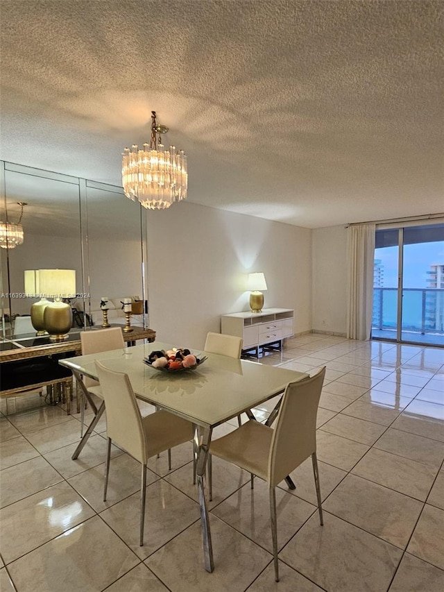 tiled dining room with a textured ceiling and a chandelier