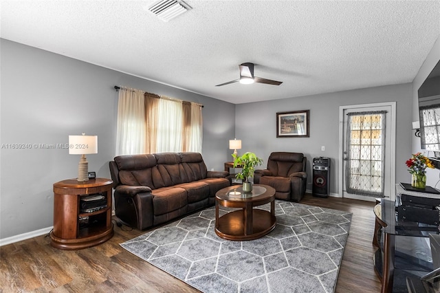 living area featuring a ceiling fan, baseboards, visible vents, and wood finished floors