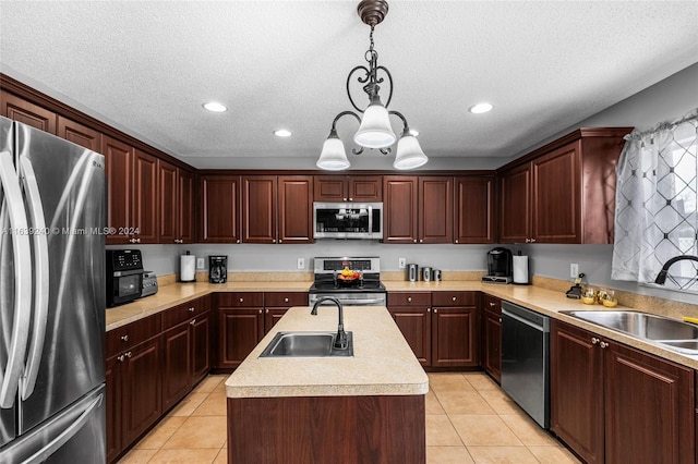 kitchen with light tile patterned floors, appliances with stainless steel finishes, light countertops, and a sink