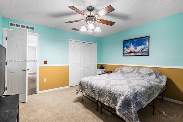 carpeted bedroom featuring a closet, visible vents, a textured ceiling, and baseboards