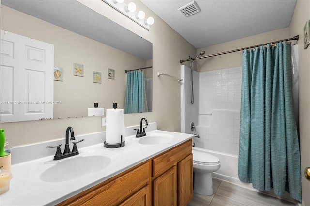 bathroom with double vanity, shower / bath combination with curtain, visible vents, and a sink