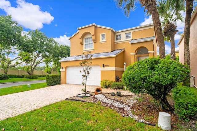 view of front of property with a garage and a front lawn