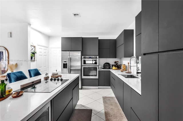 kitchen featuring light tile patterned floors, stainless steel appliances, and sink