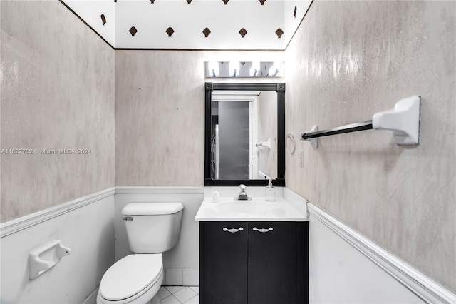 bathroom with toilet, vanity, and tile patterned floors