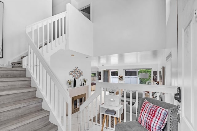 stairway featuring a high ceiling and hardwood / wood-style floors