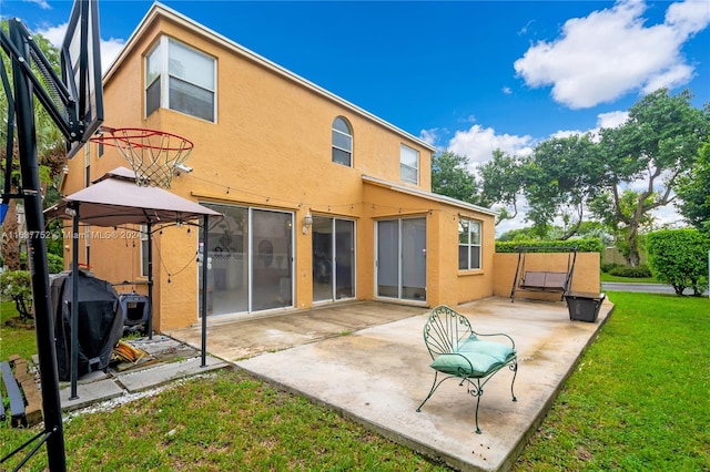 rear view of property featuring a gazebo, a yard, and a patio area