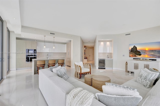 living room with light tile patterned flooring, wine cooler, and sink