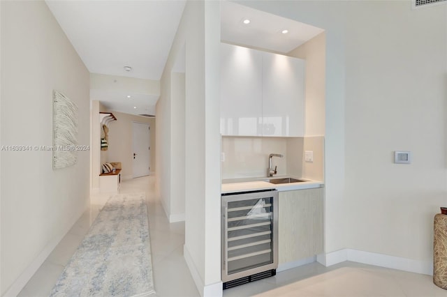 bar with sink, beverage cooler, and light tile patterned flooring