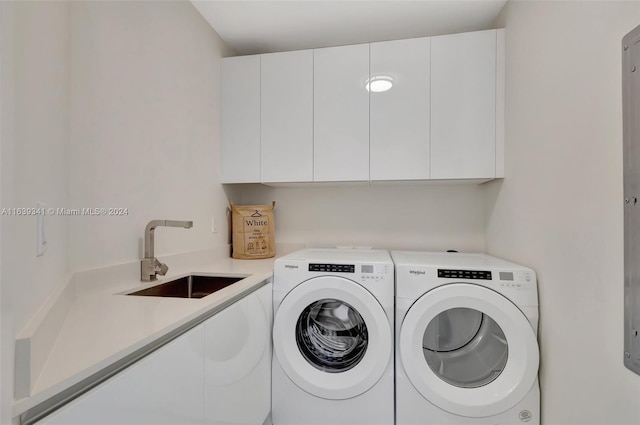 laundry area with washing machine and dryer, sink, and cabinets