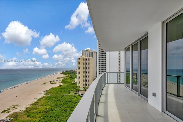 balcony with a water view and a view of the beach