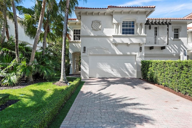 mediterranean / spanish home featuring a front lawn and a garage