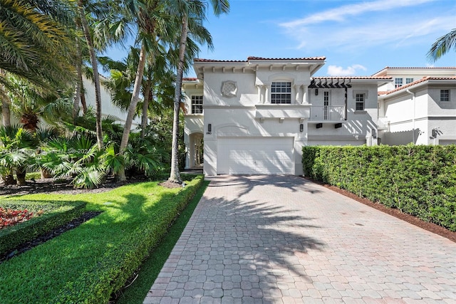 mediterranean / spanish home featuring a garage and a front yard